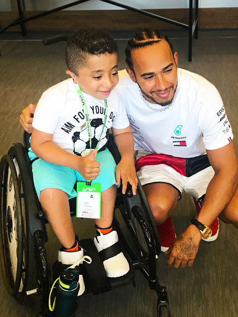 Junge in Rollstuhl mit Lewis Hamilton