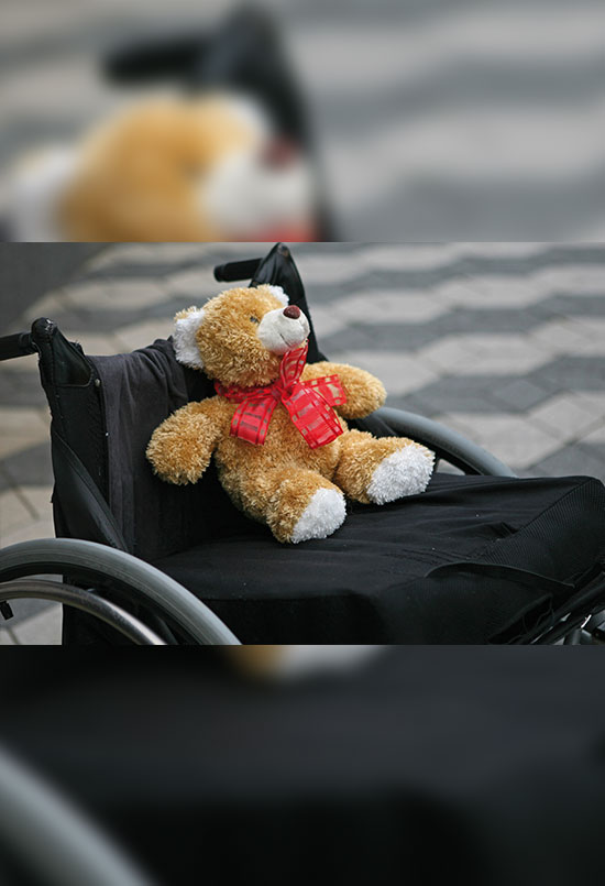 Teddybär im Rollstuhl