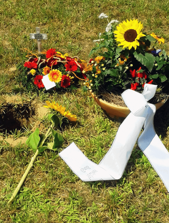 Trauergesteck auf dem Friedhof mit Sonnenblumen